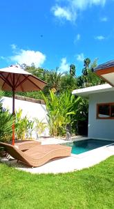 乌鲁瓦图Bingin Pura Vida Villas的一个带遮阳伞和椅子的庭院和一个游泳池