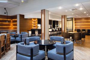 西得梅因西得梅因喜来登酒店的一间设有蓝色桌椅的餐厅和一间酒吧