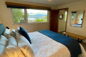 LindisfarneSpacious Apartment - Warm and Welcoming in Lindisfarne, 8 min from CBD的一间卧室设有一张大床和大窗户