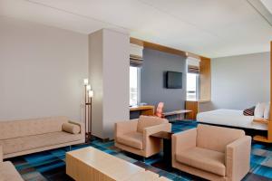 波林布鲁克柏林布鲁克雅乐轩酒店的酒店客房配有一张床、一张沙发和椅子。