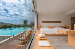张家界Avatar Mountain Resort的一间带两张床的卧室和一个带游泳池的阳台
