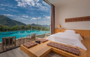 张家界Avatar Mountain Resort的一间卧室配有一张床,享有游泳池的景色