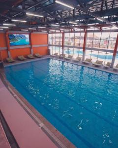 博斯特里Танхаус в Байтур резорте и Спа的大楼内带椅子的大型游泳池