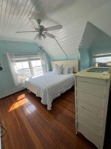奥克布拉夫斯Inkwell Beach Cottage的一间卧室配有一张床和吊扇