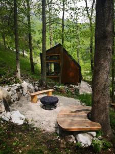 科巴里德Mountain lodge Forte Emilia的树林中的小屋,有长凳和树