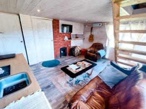LieplaukėCharming Sauna Cottage in a Horse Ranch的客厅配有真皮沙发和桌子