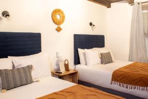 危地马拉安地瓜Mestizo Antigua的一间卧室设有两张床,墙上设有一面镜子