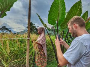 SindanglakaFarmstay Manangel的把一个女人的照片拍成田野的男人