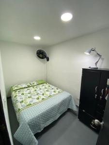 麦德林apartamento en Medellin, Santa Monica的一间小卧室,配有床和灯