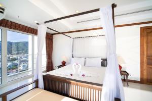 芭东海滩Patongtower Duplex Seaview4BR2901的一间卧室配有一张带两个天鹅的床