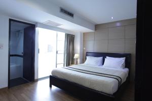 曼谷纳南泰套房酒店的一间带大床的卧室和一间浴室