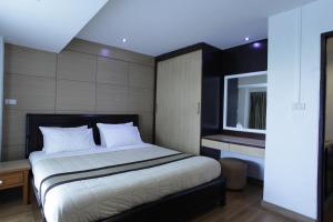 曼谷纳南泰套房酒店的一间卧室配有一张带白色床单的大床