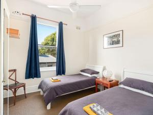 悉尼Lord Wolseley Hotel的一间卧室设有两张床和窗户。