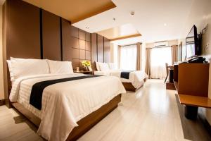 长滩岛ECL Resort Hotel Boracay的酒店客房设有两张床和电视。