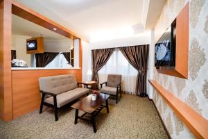 马六甲马六甲国际贸易中心酒店的一间酒店客房,配有沙发、桌子和电视