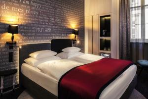 维也纳维也纳美居第一酒店的一间卧室配有一张带红色毯子的大床