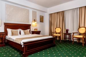 皮特什蒂维多利亚酒店的酒店客房,配有一张床和两把椅子