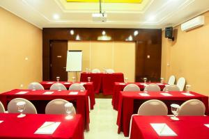 马卡萨Favor Hotel Makassar City Center By LIFE的一间会议室,配有红色的桌子和白色的椅子