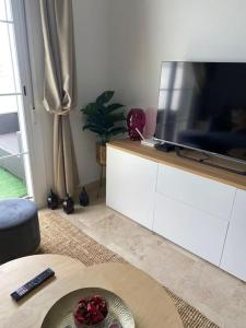 马尼尔瓦Penthouse familial avec vue mer的客厅配有大电视和桌子
