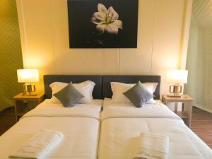 话毛生The Dome @ Gua Musang的一间卧室配有两张带白色床单和两盏灯的床。