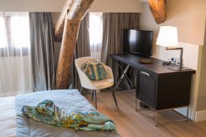 基奥贾格兰蒂意大利酒店的一间卧室配有一张床和一张书桌及电视