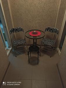 尼什Mila lux的一张桌子和两把椅子,上面有红色的盘子