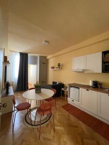 拉文纳Apartment Hotel Marchesini的厨房以及带桌椅的起居室。