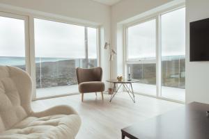 托尔斯港Nordic Swan Aparthotel with Panoramic Seaview的客厅配有椅子、桌子和窗户