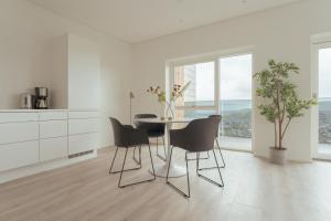 托尔斯港Nordic Swan Aparthotel with Panoramic Seaview的白色的厨房配有桌椅