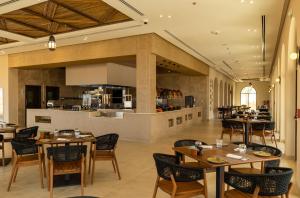 里瓦Bab Al Nojoum Bateen Liwa的一间带桌椅的餐厅和一间厨房