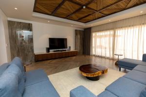 里瓦Bab Al Nojoum Bateen Liwa的客厅配有2张蓝色沙发和1张咖啡桌