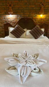 索拉哈潮塔里花园度假村的床上的白色毯子,床上有花