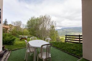 圣雷热雷梅累兹Les Arolles - Appartement vue sur la montagne的美景庭院内的桌椅