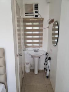 长滩岛碧海蓝天沙滩酒店的白色的浴室设有水槽和镜子