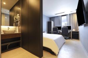 原州市Wonju Brown Dot Hotel Corporate Business的一间酒店客房 - 带一张床和一间浴室