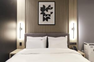 原州市Wonju Brown Dot Hotel Corporate Business的卧室配有一张带白色床单和枕头的大床。
