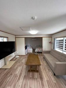 那霸駅徒歩２分の貸切一軒家【Villa Kokusai】的带沙发和平面电视的客厅