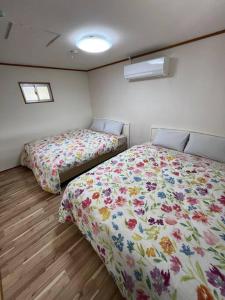 那霸駅徒歩２分の貸切一軒家【Villa Kokusai】的一间卧室设有两张床和两个窗户。