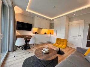 泰克伦堡DRIEHOF LifeStyle Comfort Apt 4的客厅配有桌子和黄椅