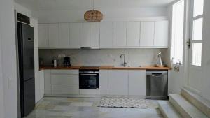 纳乌萨Lydia's Charming House in Naoussa的厨房配有白色橱柜和水槽