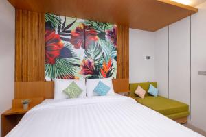 登巴萨Aralea Coliving的一间卧室配有一张带热带壁画的大型白色床。