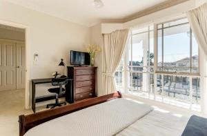 墨尔本Cosy private room easy access to city & airport的一间卧室配有一张床、一张书桌和一个窗户。