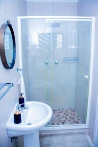 龙杜Home@Amalia’s的带淋浴和白色盥洗盆的浴室