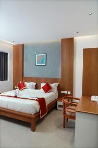 MaheRITZ AVENUE LUXURY HOTEL的一间卧室配有一张带红色枕头的大床