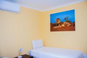 龙杜Home@Amalia’s的卧室配有一张床,墙上挂着狮子的照片