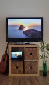 利马索尔Unique Sea & City Lifestyle Studio的一台带吉他台的平面电视