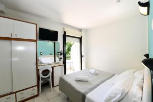 里米尼Hotel Criniera D'oro的一间卧室配有一张床和一张带镜子的书桌