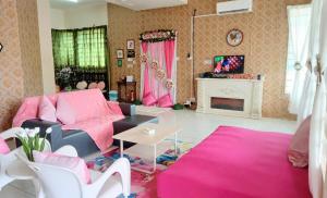 TuaranDiana Home @ Tuaran的客厅配有粉色家具和壁炉