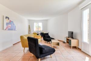 纳博讷La Villa d'Isa et Seb的客厅设有黄色和黑色椅子和电视