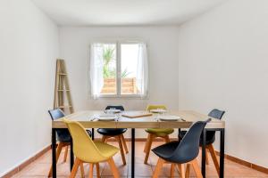 纳博讷La Villa d'Isa et Seb的一间带木桌和椅子的用餐室